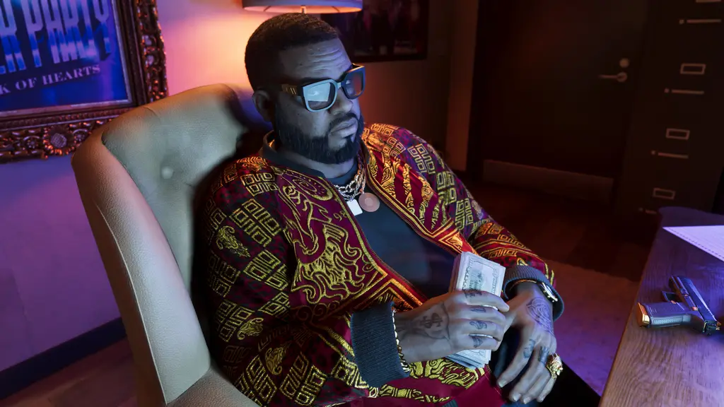 Boobie Ike seated in a leather chair holding cash