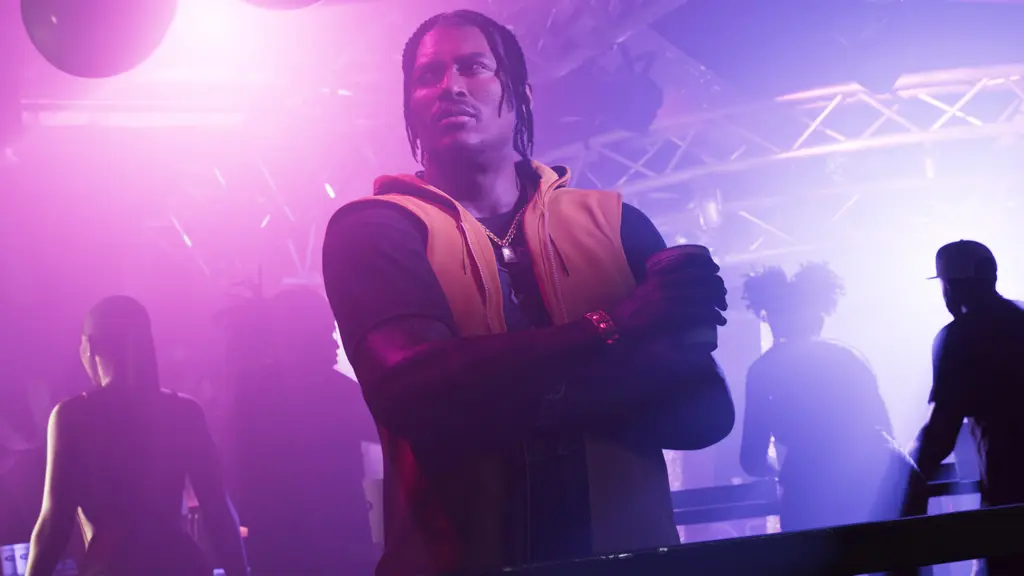 Dre'Quan Priest standing in a purple-lit club