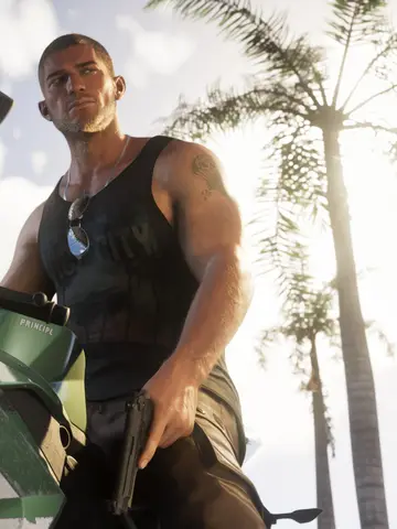 Jason Duval leaning on a green sport motorcycle under palm trees